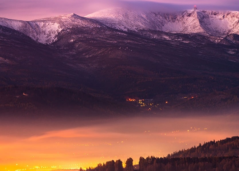 Jelenia Góra nocą, a w tle ośnieżone Śnieżne Kotły